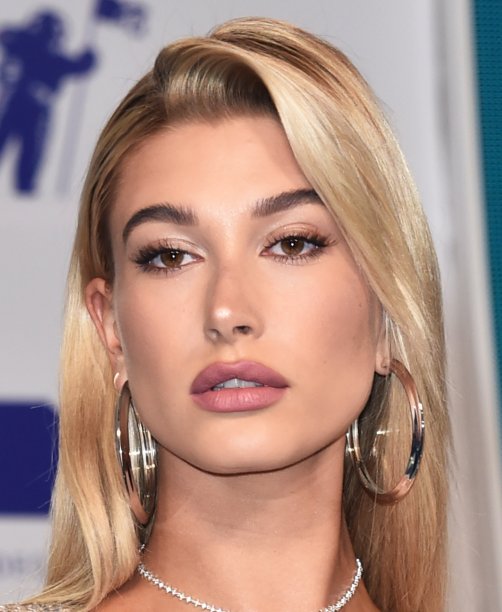 Hailey Baldwin usou tons claros e cintilantes de sombra nos olhos - o que deixou um brilho bem bonito no make. Nos lábios, apostou em um batom mate rosado.