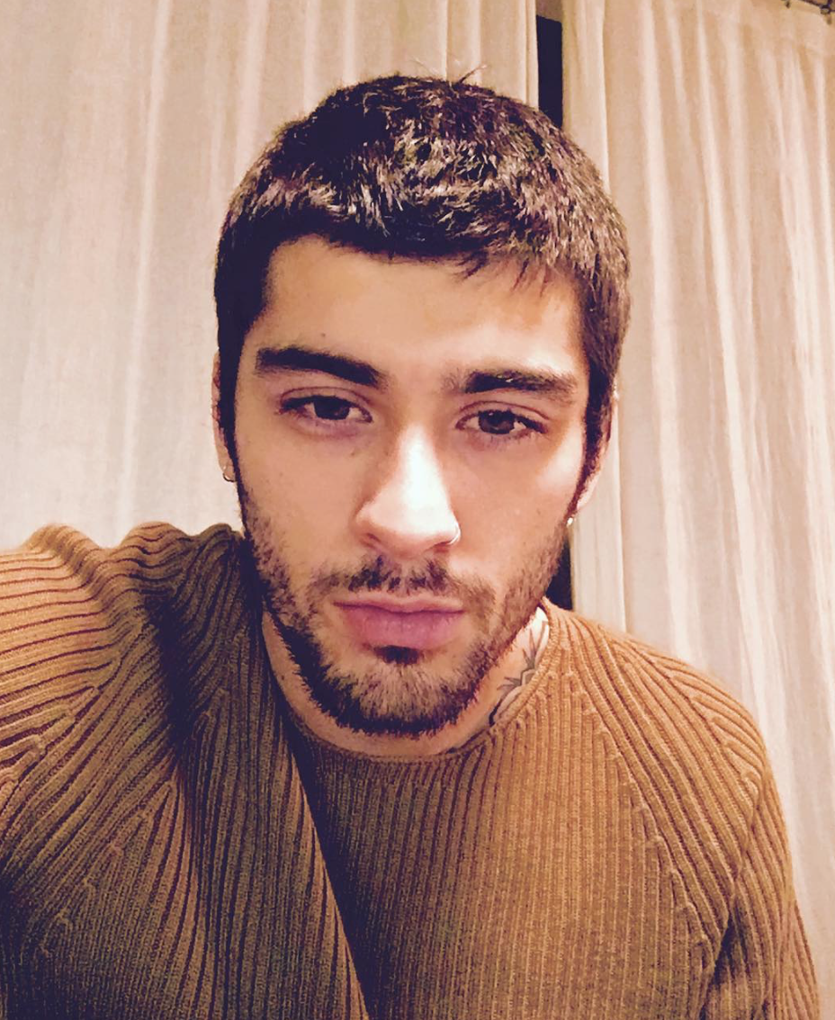 Selfie de Zayn usando um suéter bege, ele está com a expressão séria olhando para câmera