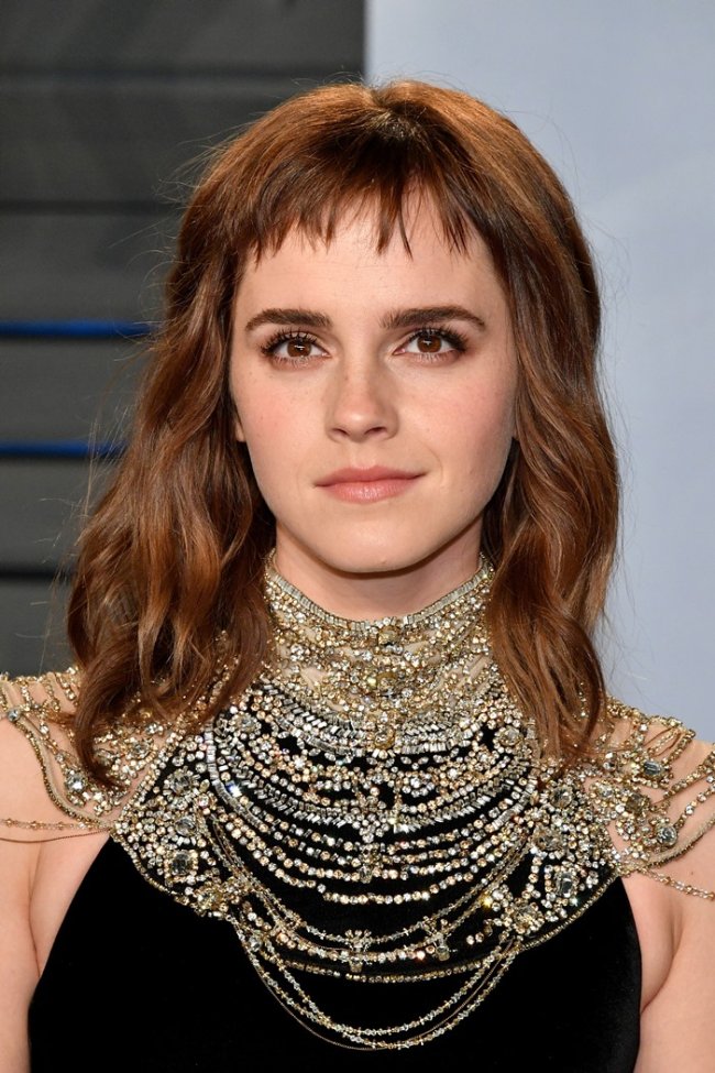ariana-emma Emma Watson com expressão séria usando múltiplos colares.