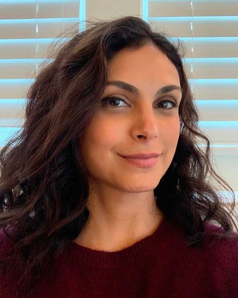 Morena Baccarin olha para a câmera com um leve sorriso no rosto