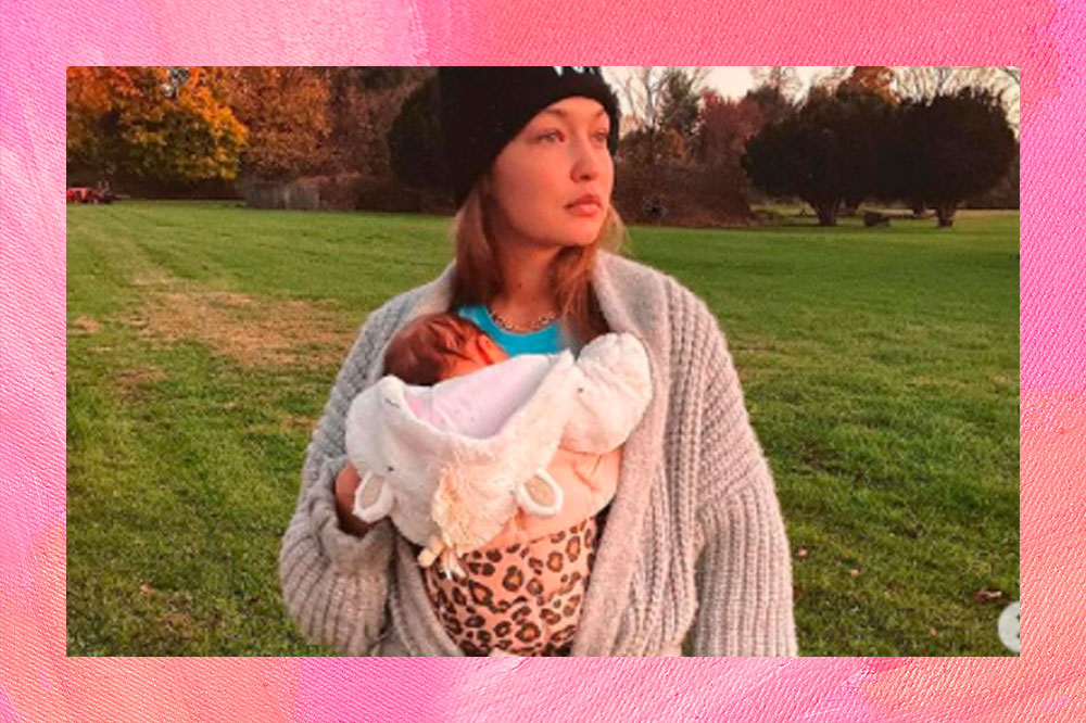 Gigi Hadid segurando a filha Khai em uma bolsa de canguru