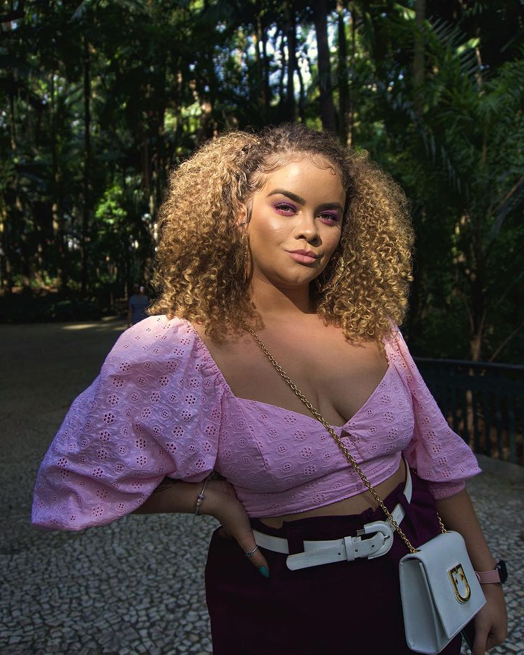 Influenciadora Nina Gabriella usando blusa rosa com short roxo