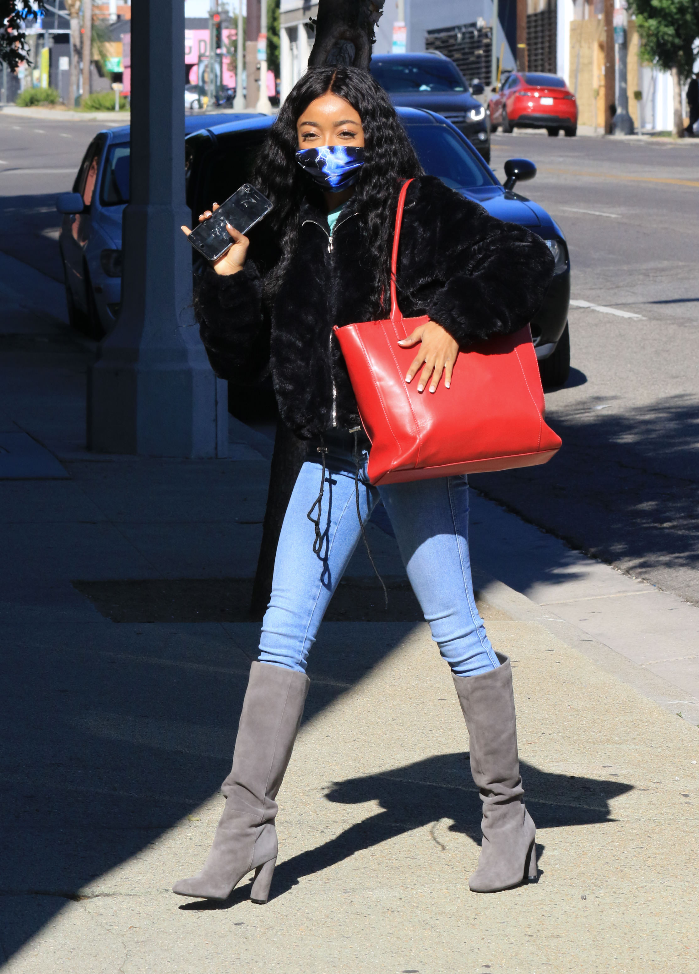look-do-dia-skai-jackson-calca-jeans-bota Skai Jackson usando casaco de pelos preto, calça jeans e bota cinza por cima