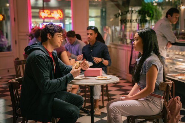 cena de Para todos os Garotos que Já Amei: Agora e Para Sempre, Lara Jean. Peter e Lara Jean estão sentados em uma mesa. Um olha para o outro