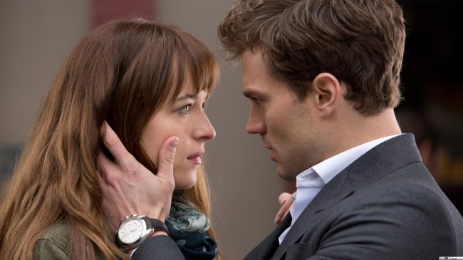 50-tons-de-cinza- Jamie Dornan segurando o rosto de Dakota Johnson com as duas mãos em Cinquenta tons de Cinza
