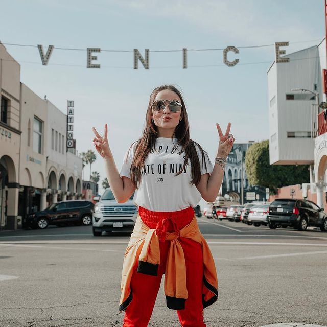 Atriz Larissa Manoela posa em rua de Venice (LA) com calça vermelha, camiseta branca e blusa laranja amarrada na cintura Atriz Larissa Manoela posa em rua de Venice (LA) com calça vermelha, camiseta branca e blusa laranja amarrada na cintura