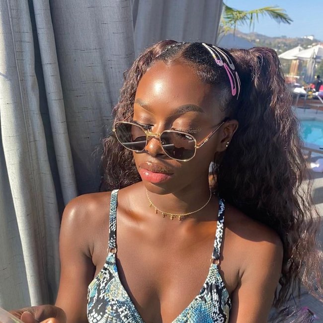 diarra-sylla-now-united-maria-chiquinha Diarra Sylla, do Now United, com maria chiquinha, presilhas coloridas, óculos escuro, posando para foto.