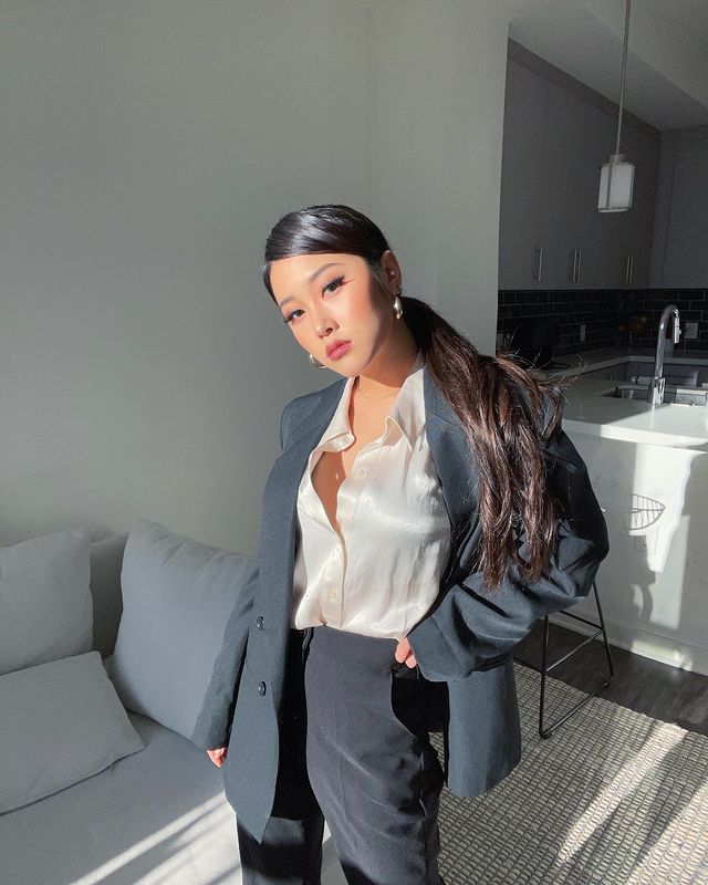 rabodecavalobaixo-heyoon Heyoon, do Now United, posando com camisa branca semi aberta, calça social escura e blazer.