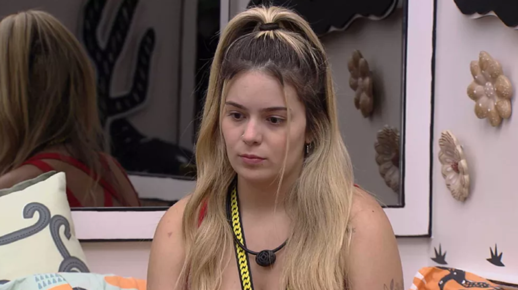 Viih Tube no BBB21 usando o colar amarelo do líder. Ela olha para baixo com expressão séria