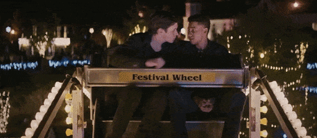com-amor-simon Dois jovens se beijando na roda gigante
