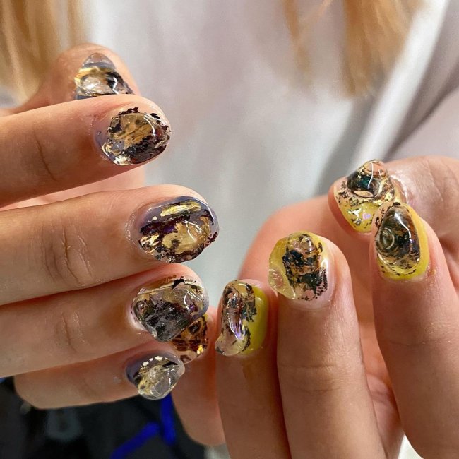 nail art gelatinosa Foto com foco nas unhas com nail art com gel, amarela e preto.