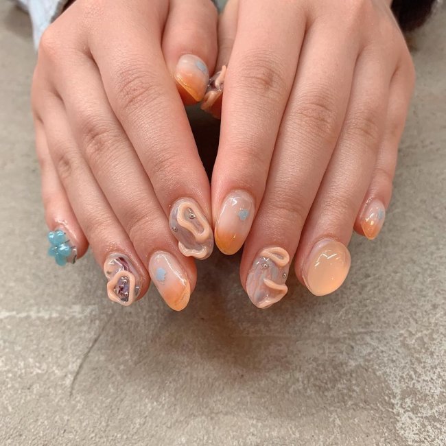 nail unha jelly Foto com nail art com gel deixando relevo nas cores laranja e azul.