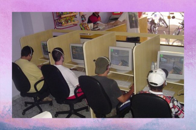 Uma lan house dos anos 90, com muitos computadores antigos e cadeiras velhas