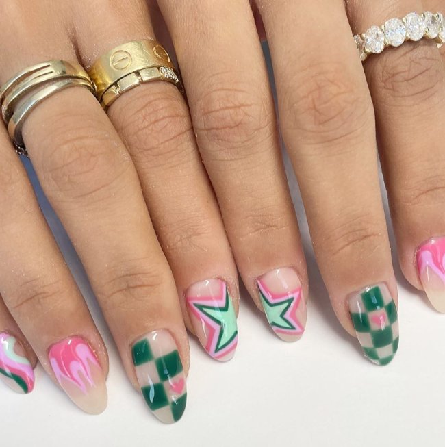 nail art quadriculada Foto com close nas unhas e tem nail art com desenho xadrez, e estrelas. Nas cores rosa, verde escuro e verde claro.