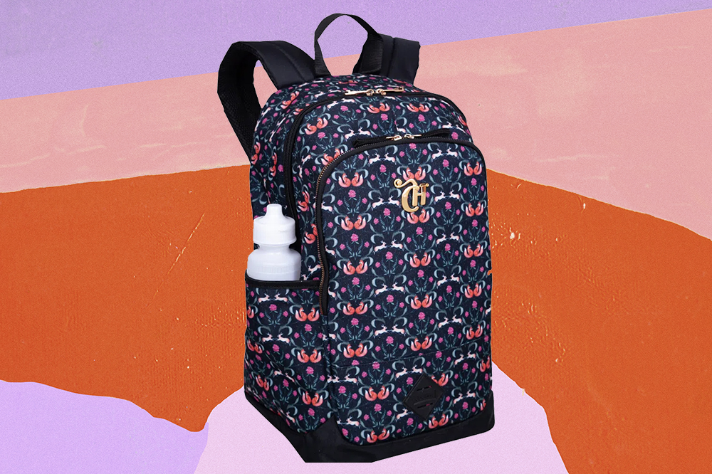 Mochila azul-marinho com estampa de raposinhas rosas da CAPRICHO com a Sestini em fundo laranja, rosa e lilás