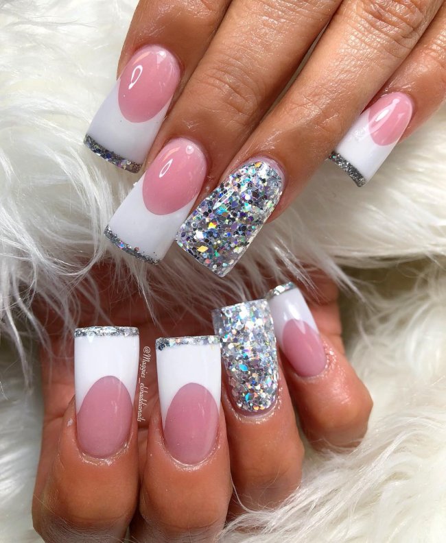 Foto com foco nas unhas com formato duck feet. As unhas estão esticadas. Com francesinha branca.