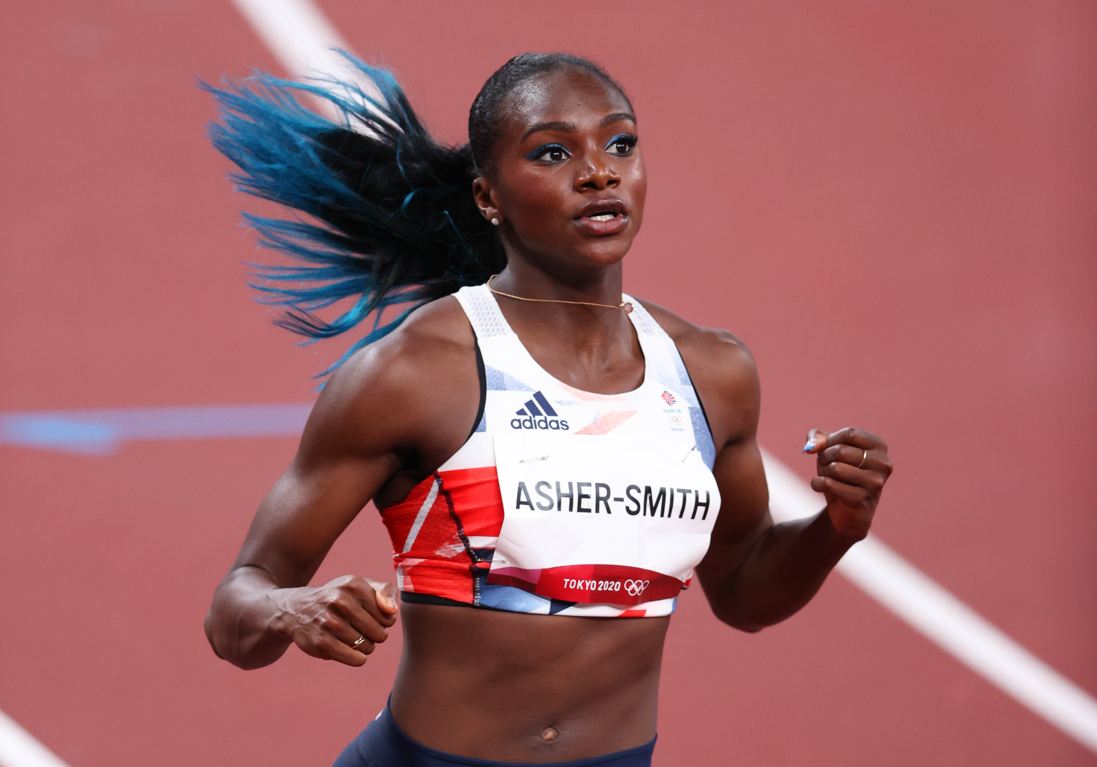 Athletics – Olympics: Day 8 A velocista Dina Asher-Smith, da Grã Bretanha, nas Olimpíadas de Tóquio. Ela está com um top branco, cabelo amarrado em um rabo, enquanto corre na pista de atletismo.