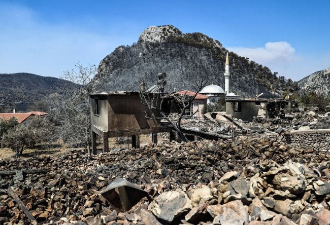 Incêndios na Turquia: causas, como ajudar e o silenciamento do governo Escombros pós-queimada em uma região do sul da Turquia. Vemos restos de casas, muita pedra e uma montanha ao fundo totalmente desmatada