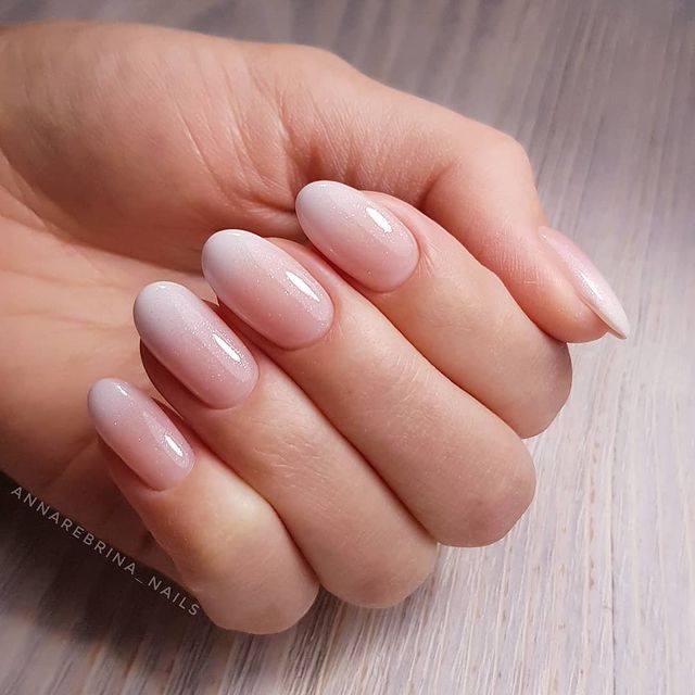 Foto de uma mão com as unhas pintadas de branco no estilo baby boomer.