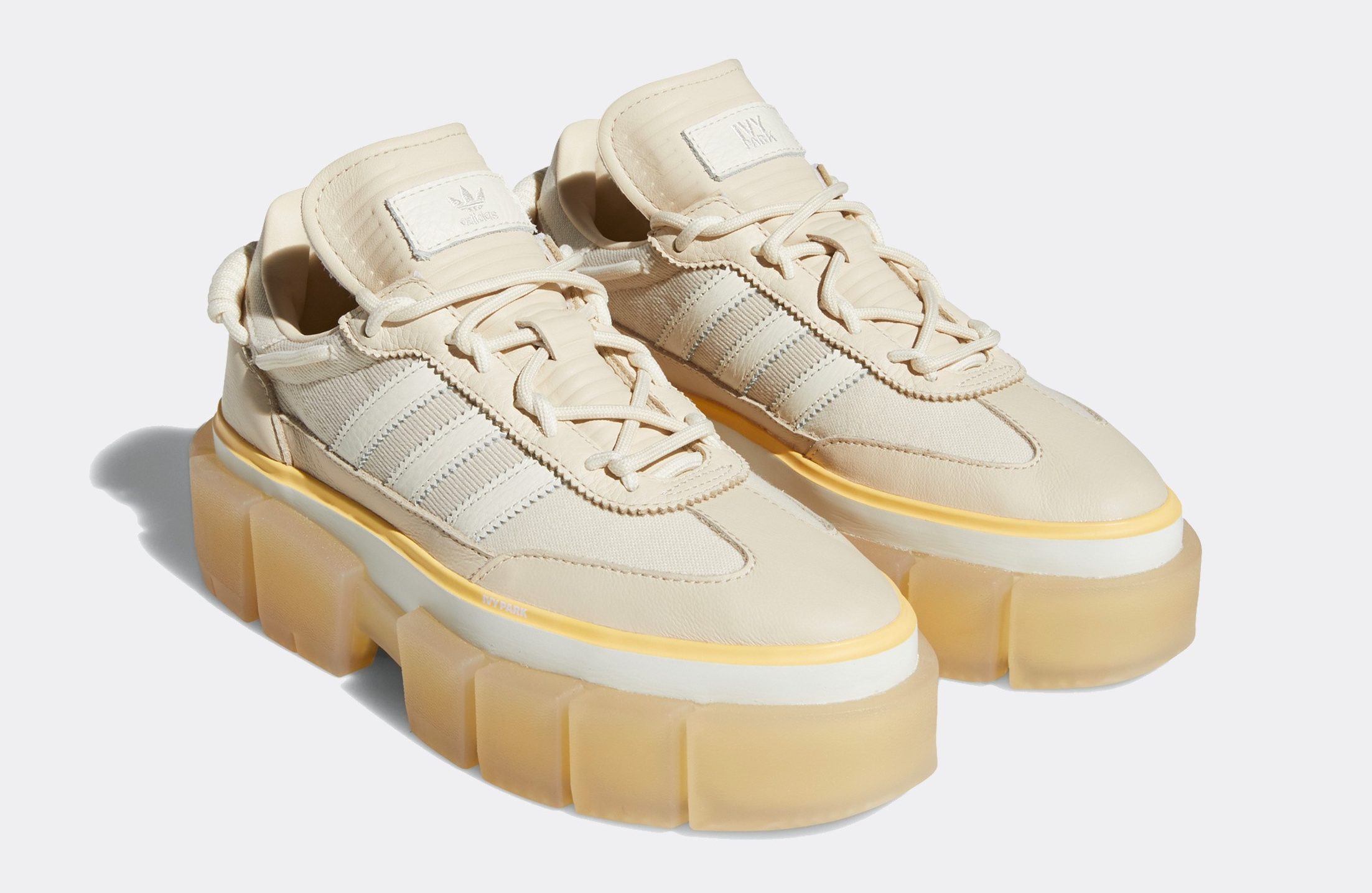 Tênis Super Sleek Chunky da coleção Adidas x IVY Park Rodeo. Ele é bege, com sola tratorada marrom clara e listras off white nas laterais.