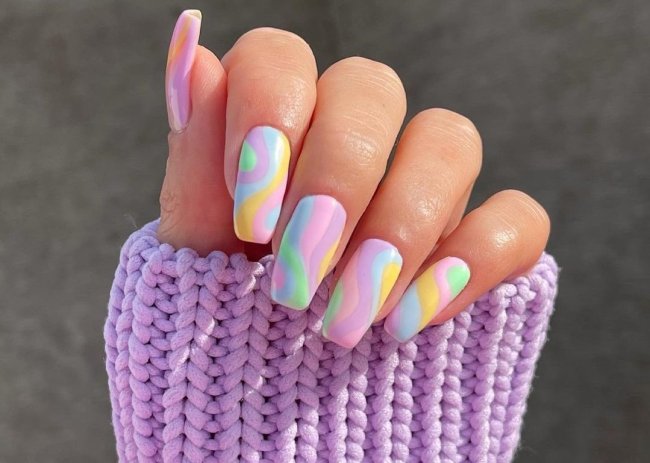 unhas coloridas em tom pastel Foto com close nas unhas com esmaltes coloridos em diversas cores.