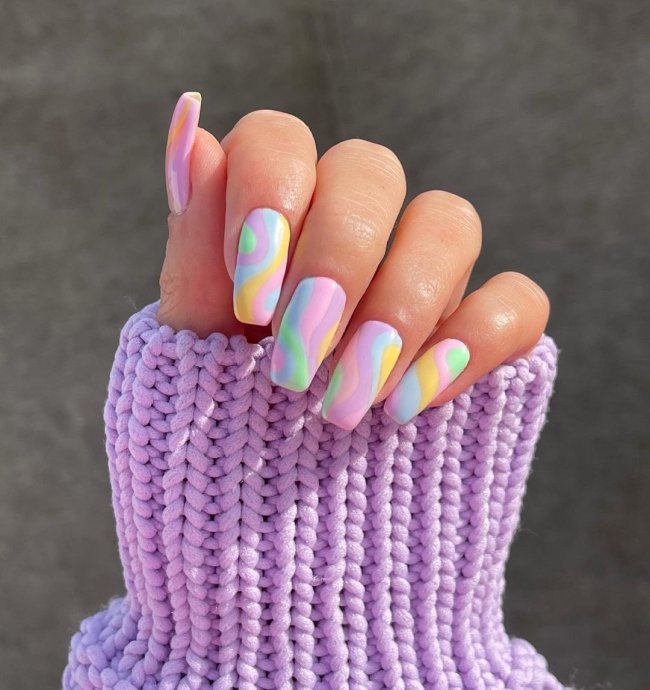 unhas coloridas em tom pastel Foto com close nas unhas com esmaltes coloridos em diversas cores.