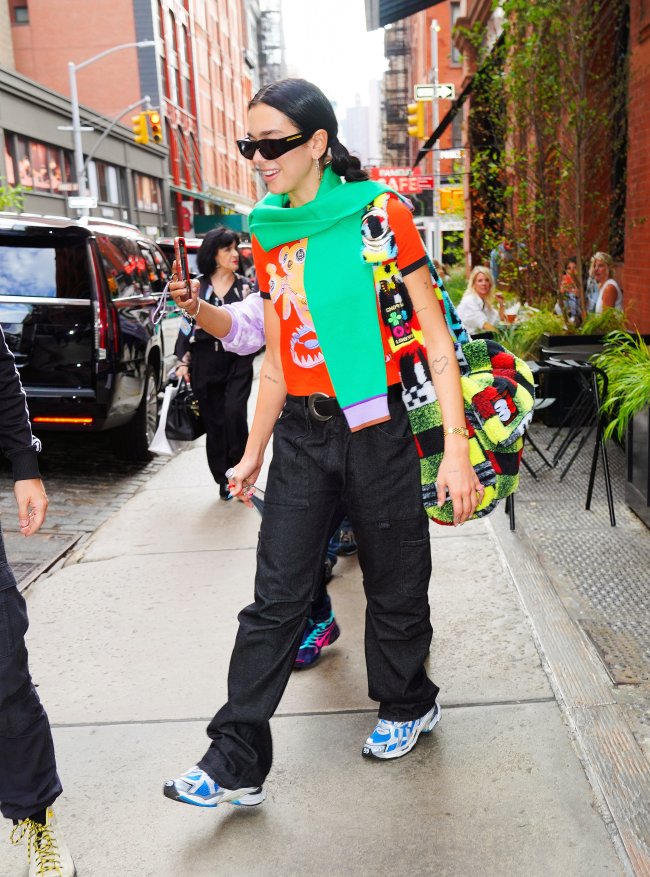 Celebrity Sightings In New York City – September 22, 2021 Cantora Dua Lipa andando pelas ruas de NY com blusa colorida e cachecol verde.