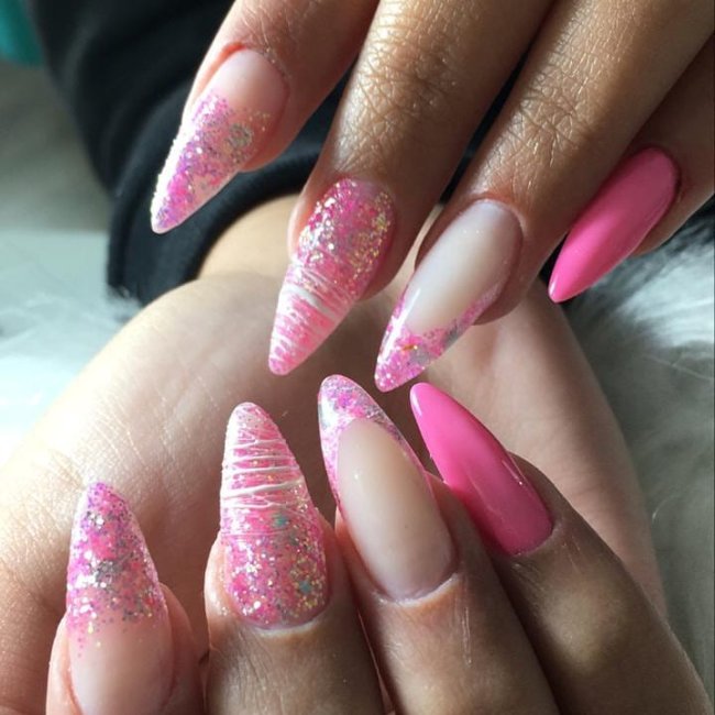 francesinha colorida Foto de uma mão segurando um esmalte e exibindo as unhas com glitter nas pontas.