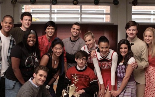 Foto de divulgação da série Glee. Nela, aparecem um grupo de pessoas posando junto de um prêmio.