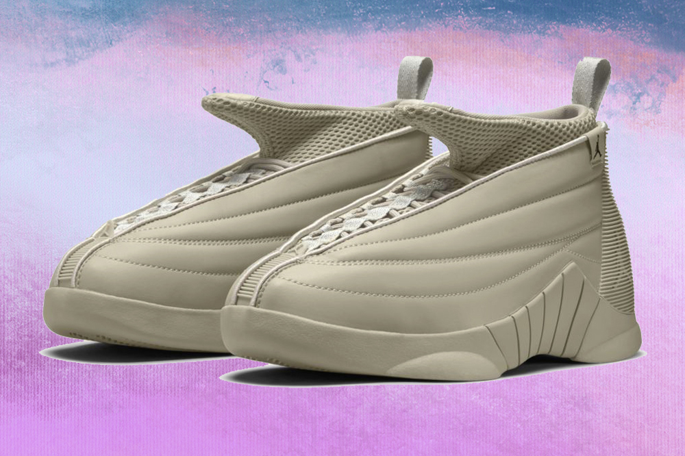 Foto do tênis cinza no modelo Air Jordan 15 da coleção da Billie Eilish com a Nike em fundo lilás, roxo e azul