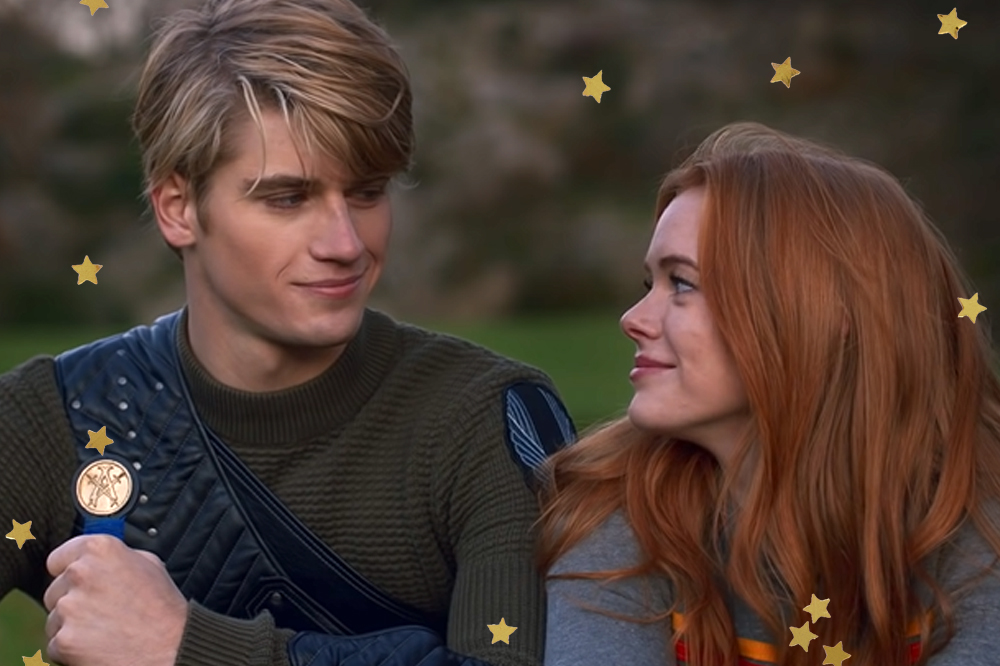 Danny Griffin e Abbey Cowen como Sky e Bloom em cena de Fate: A Saga Winx; eles estão sentados no chão lado a lado olhando e sorrindo levemente; estrelas amarelas decoram a imagem