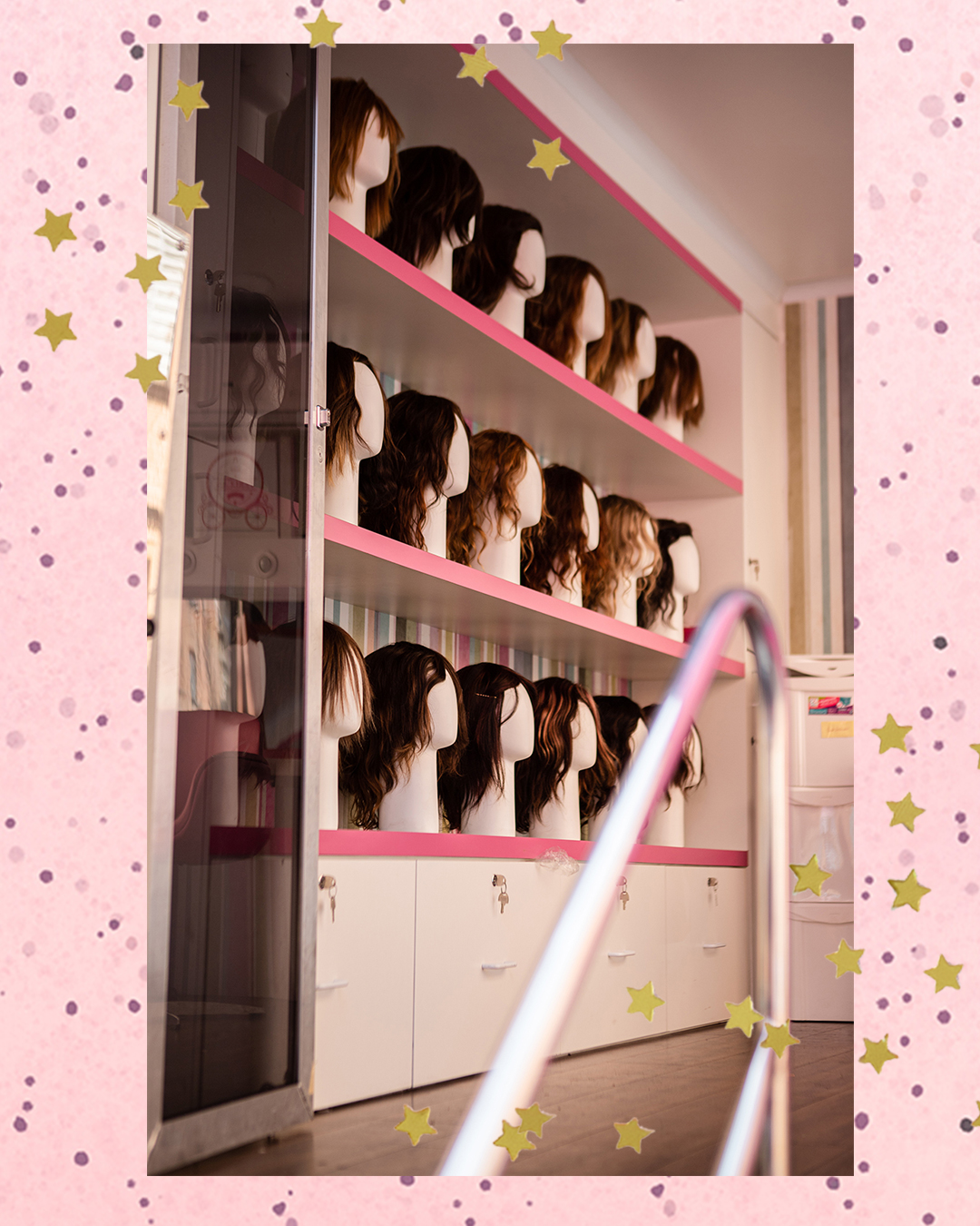 doar-cabelo-ong-cabelegria Foto de várias perucas em prateleiras que ficam dentro do Banco de Perucas Móvel, da ONG Cabelegria, em fundo rosa com bolinhas e estrelas douradas