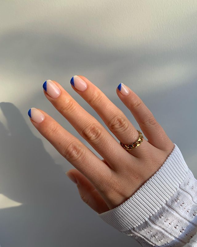 francesinha-espanhola-azul Foto de uma mão com as unhas decoradas com uma francesinha espanhola azul escura.