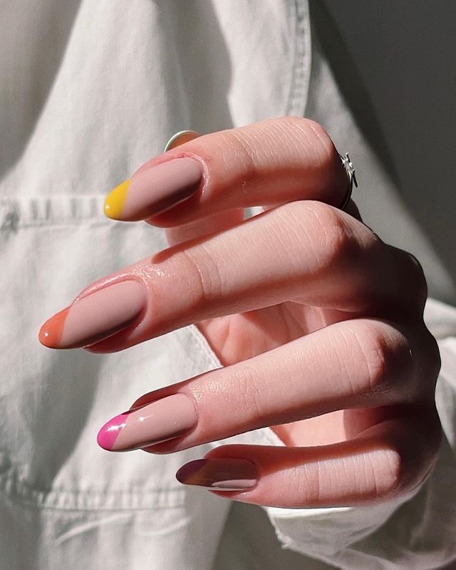 francesinha-espanhola-colorida Foto das mãos de uma mulher. As unhas das mãos estão decoradas com a nail art de francesinhas espanholas coloridas.