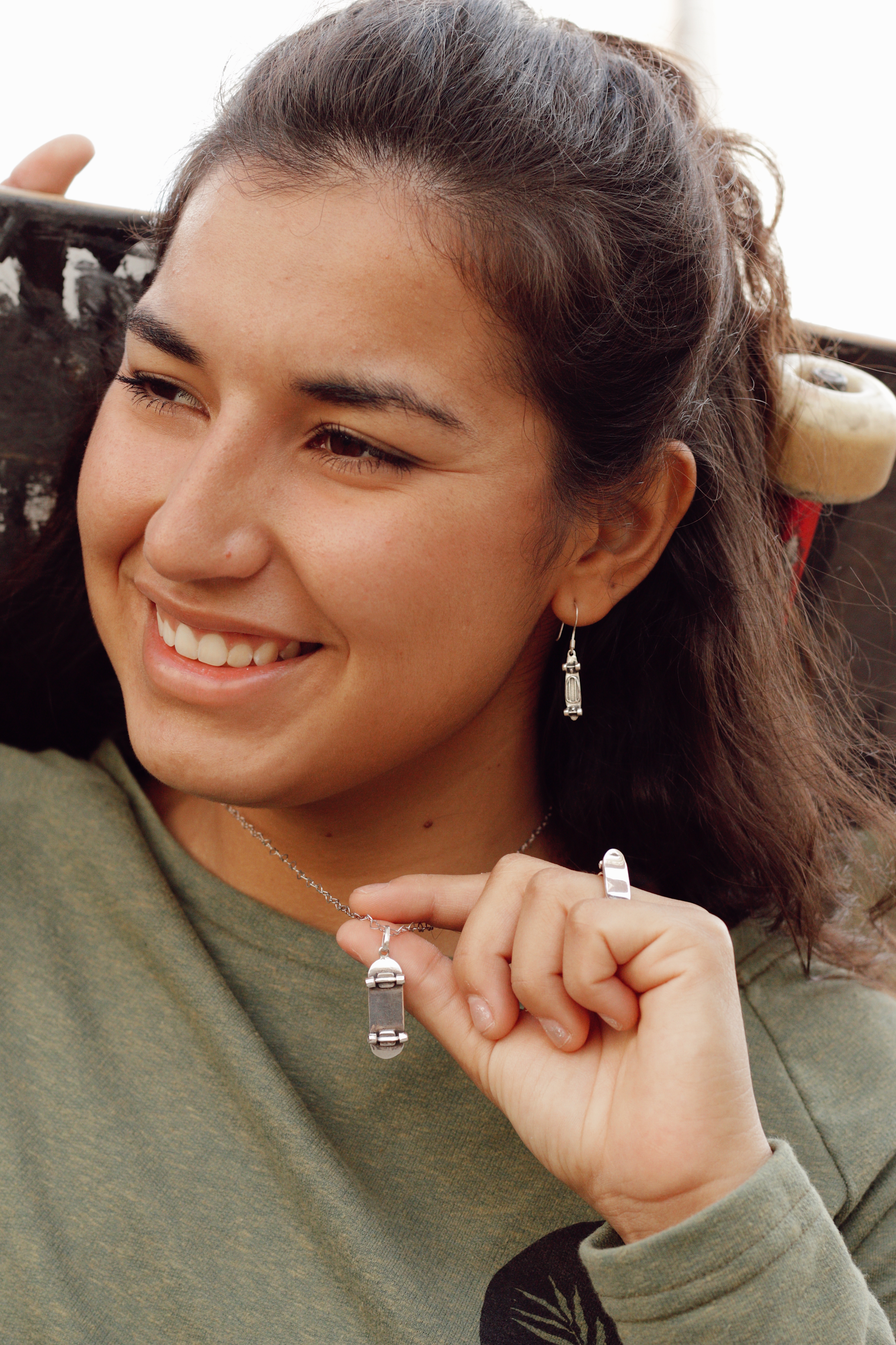 Thais Gazarra sorrindo enquanto mostra seu colar de skate