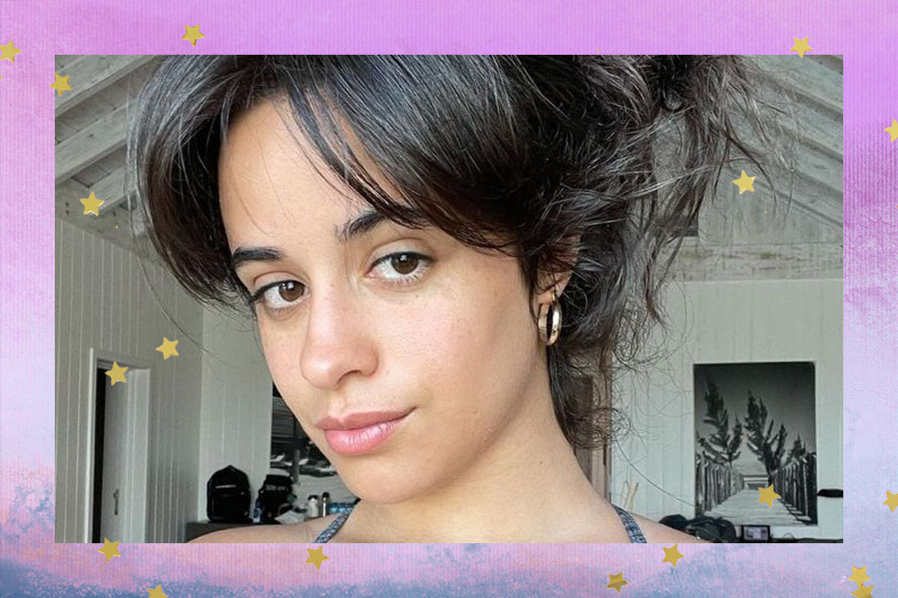 Foto da cantora Camila Cabello. Nela, ela está de cabelo preto, preso em coque e com franjas.