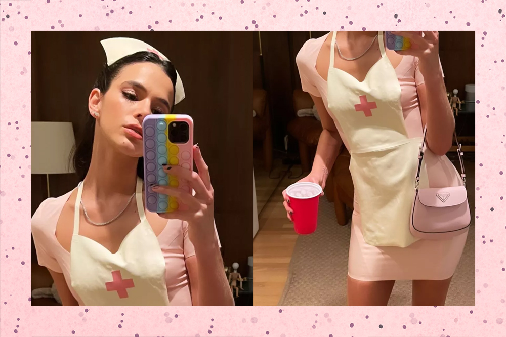 Bruna Marquezine vestida de "enfermeira sexy". Ela usa um vestido curto rosa claro e um avental com uma cruz vermelha