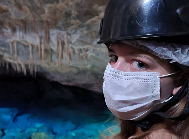 Foto gruta mascara – Bonito Foto da integrante da Galera, Antonela Andrade, em uma gruta com águas cristalinas, em Bonito. Antonela é branca dos olhos azulados.