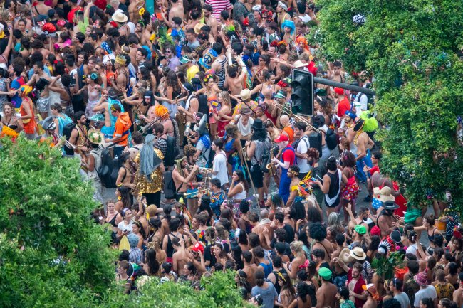 Bloco de rua no bairro do Flamengo, no Rio de Janeiro, em um mundo pré-pandêmico. A multidão está se divertindo.