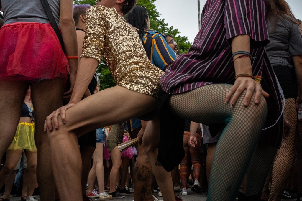 Duas pessoas rebolando com as bundas coladas no meio do bloco de Carnaval