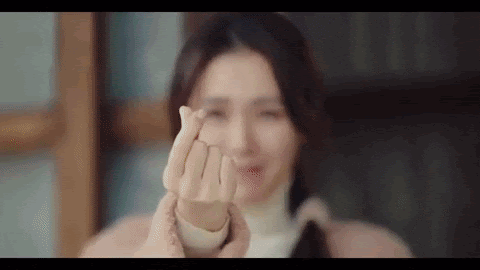 Gif de Pousando no Amor coração com os dedos Mulher faz sinal de