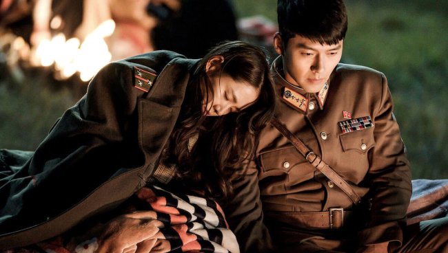 Son Ye-jin e Hyun Bin, casal de Pousando no Amor, estão noivos na vida real Cena da série Pousando no Amor. Personagens principais estão sentados. A mulher está dormindo encostada no ombro do homem