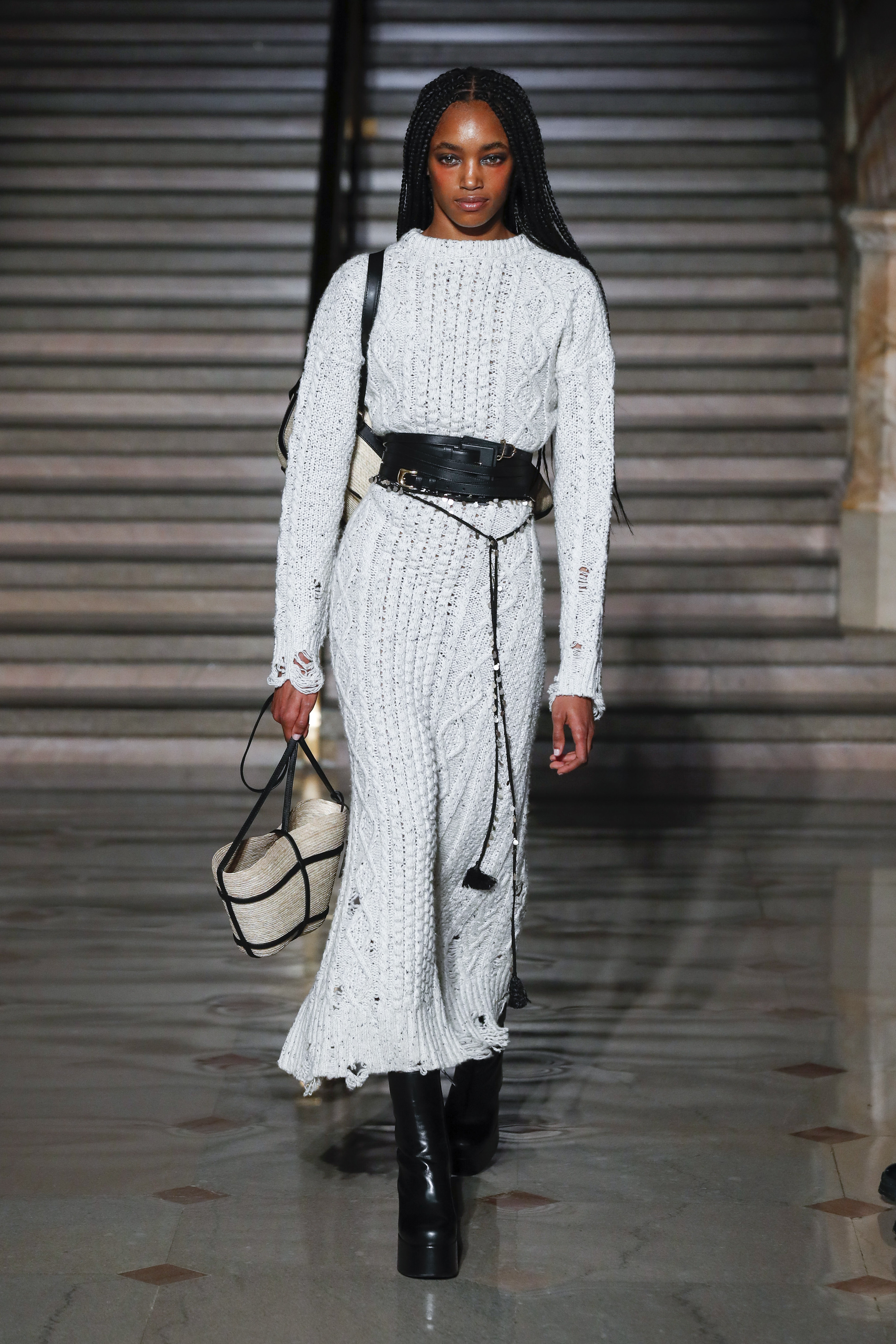 Altuzarra – Runway – Fall/Winter 2022-2023 New York Fashion Week Modelo usando vestido branco de tricô longo com cinto preto e segurando uma bolsa em Desfile da Altuzarra na semana de moda de Nova York