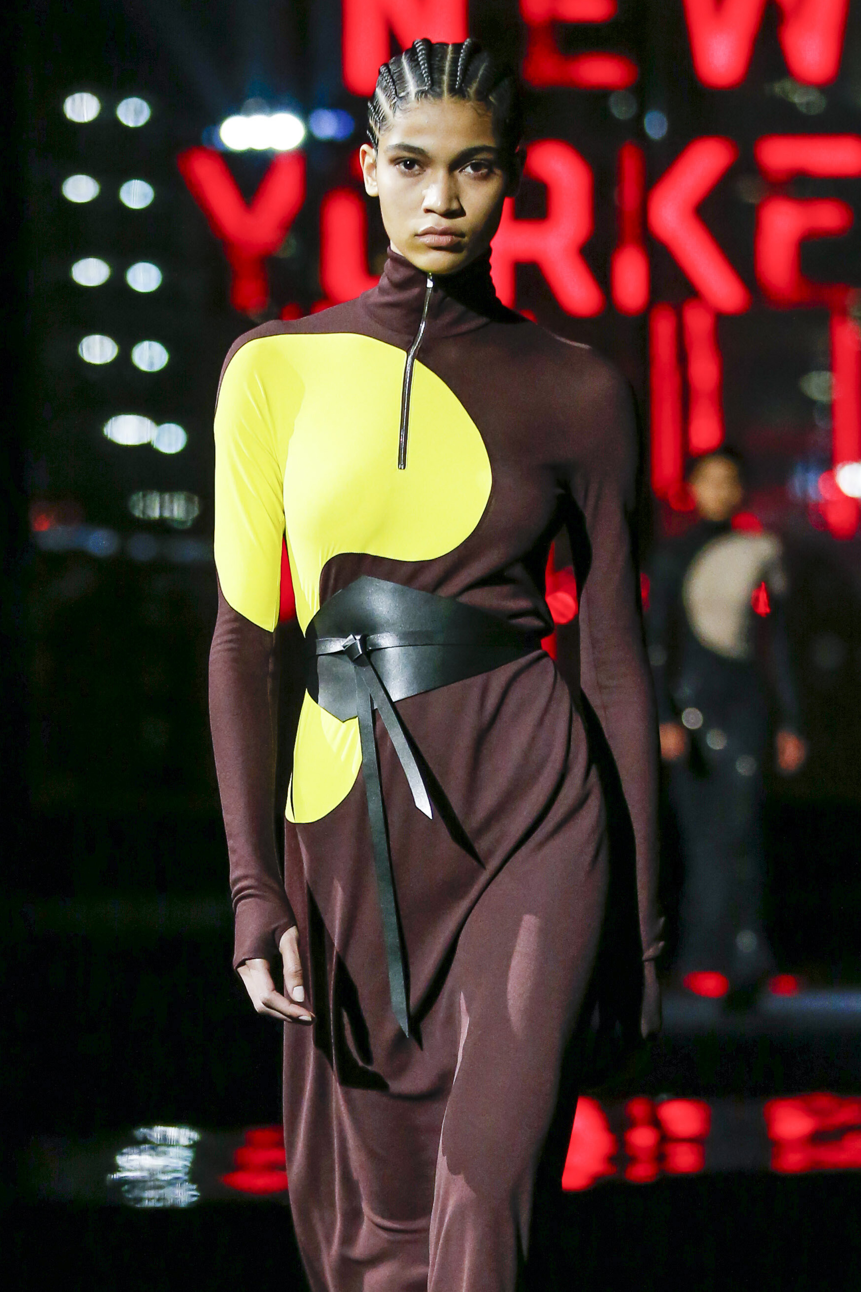 Tory Burch – Runway – Fall/Winter 2022-2023 New York Fashion Week Modelo usando vestido marrom e amarelo com cinto preto em desfile da Tory Burch na semana de moda de Nova York