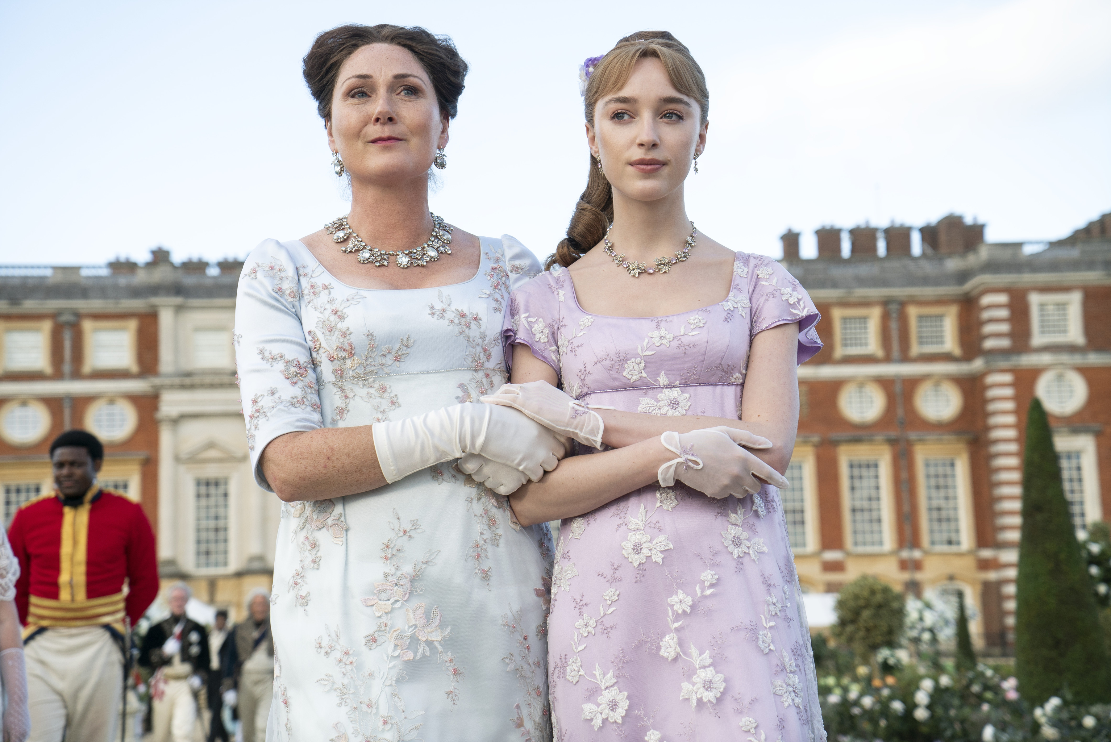 BRIDGERTON_206_Unit_05094R Imagem mostra da esquerda para a direita Ruth Gemmell como Lady Violet Bridgerton, Phoebe Dyvenor como Daphne Basset usando jóias prateadas em cena do 6º episódio da segunda temporada de Bridgerton.