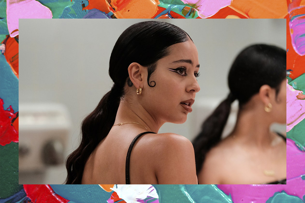 Maddy Perez (Alexa Demie) em Euphoria olhando para o lado com expressão facial confusa. O fundo da montagem é todo colorido