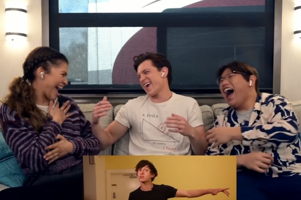 Zendaya, Tom Holland e Jacob Batalon dando risada com um frame de Tom mais novo em seu teste para o primeiro filme de Homem-Aranha