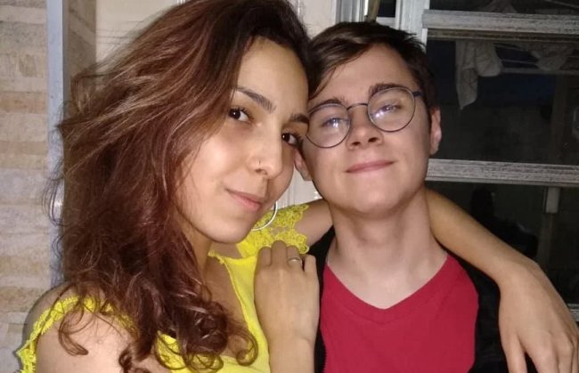 Foto de Isabela abraçada a Rafael Miguel. Ela tem cabelo castanho e usa uma blusa amarela. Ele usa óculos e uma camiseta vermelha.