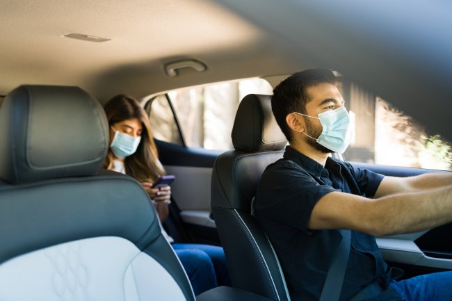 Homem dirigindo um carro e trabalhando como motorista de carona durante a pandemia de coronavírus