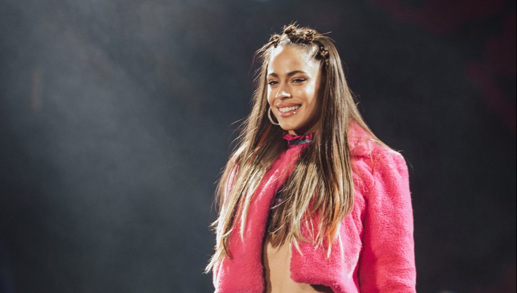 Mulher com blusa rosa em palco